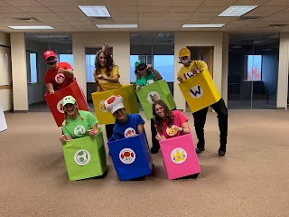 Employees dressed up as characters from Mario Kart in racecars for Halloween