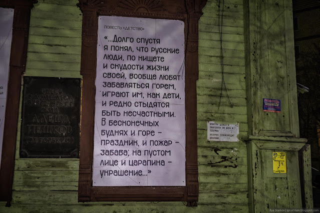 Информационный плакат в оконным проемах деревянного дома