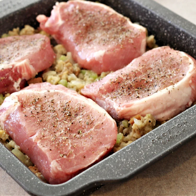 Pork chops in pan on top of stuffing