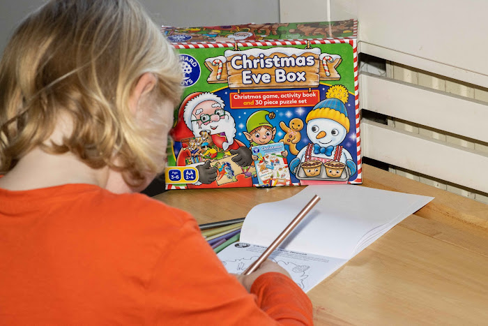 a child doing colouring in from the Orchard Toys Christmas Eve box