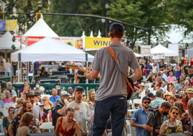 A man playing a guitar at The Utah Arts Festival