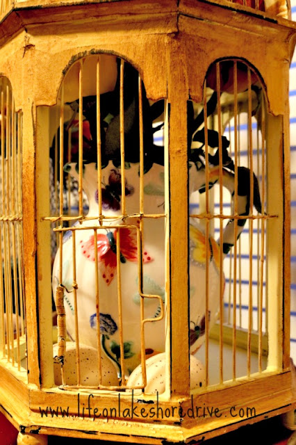 spring decor with bird cage, butterfly tea pitcher,