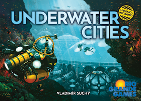 The box cover art: a view of a series of domed underwater habitats, with a couple of people in scuba gear swimming nearby, and a submersible working vehicle in the foreground.