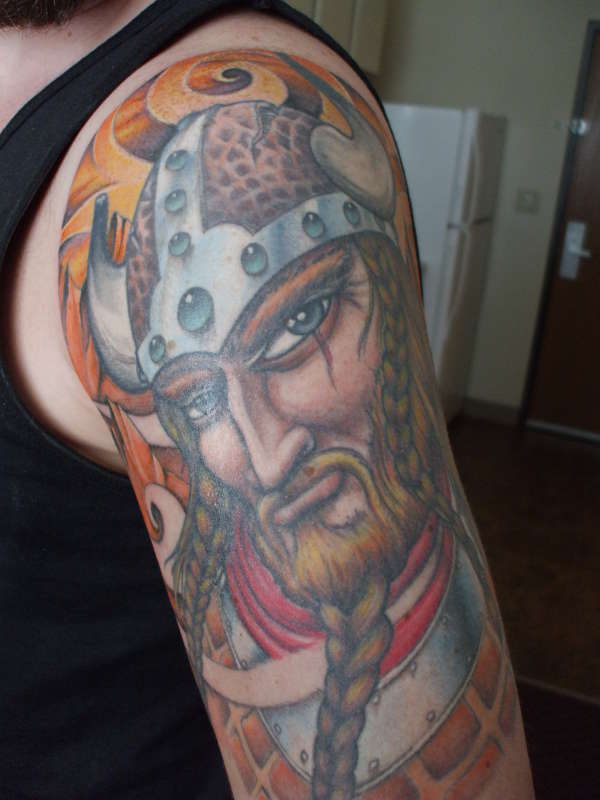 Picture of a colorrich viking tattoo featuring a blonde headed man with 
