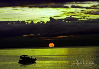 Cruise ship sailing towards the horizon with the setting sun at Manila Bay 