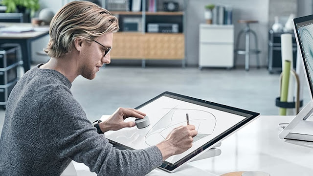 дизайнер работает за моноблоком Microsoft Surface Studio