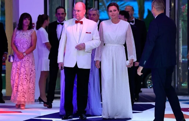 Princess Charlene wore an ivory gown by Akris. Diamond earrings. Camille Gottlieb wore a blue cape gown by Zuhair Murad