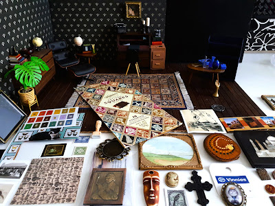 One-twelfth scale modern miniature study scene with a range of items of miniature art set out neatly in front of it.