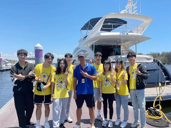 ▲亞果遊艇公司船長李仁瑋(中間 藍色上衣)，向同學分享海上開遊艇要注意的事項。（記者林明佑翻攝）
