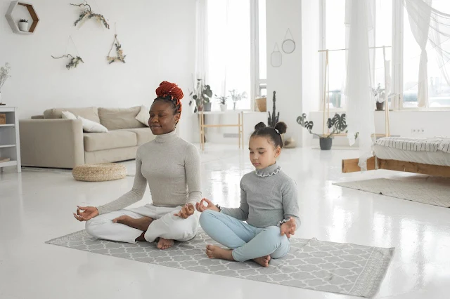 A parent and child practicing yoga together in their living room, demonstrating the family-friendly nature of yoga.