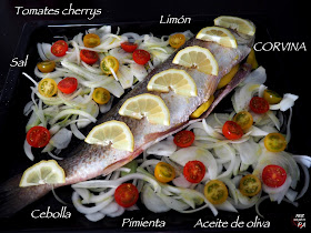 Corvina al horno con limón y guarnición de tomates cherrys y cebolla.