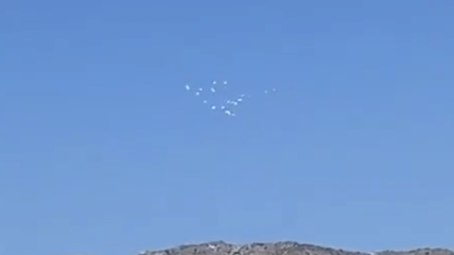 UFOs flying across Nevads are filmed disappearing from view and reappearing.