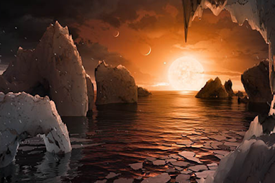 Três desses planetas estão na zona habitável. A expectativa é que eles possam ter oceanos de água em forma líquida.   Ilustração (NASA/JPL/Divulgação) A Nasa anunciou hoje que encontrou o primeiro sistema solar com sete planetas de tamanho similar ao da Terra pela primeira vez na história. O sistema foi encontrado a cerca de 39 anos-luz de distância–uma distância relativamente pequena em termos cósmicos. Dos sete planetas, três estão dentro de uma zona habitável, onde é possível ter água líquida e, consequentemente, vida. Os astros mais próximos do seu sol devem ser quentes demais para ter água líquida e os mais distantes devem ter oceanos congelados. Os planetas orbitam uma estrela anã chamada Trappist-1, que é similar ao Sol e um pouco maior do que Júpiter. Segundo a agência espacial, os astros têm massas semelhantes à da Terra e são de composição rochosa. A expectativa da Nasa é que, na pior das hipóteses, ao menos um dos planetas tenha temperatura ideal para a presença de oceanos de água em forma líquida, assim como acontece na Terra. As observações preliminares indicam que um dos planetas pode ter oxigênio em sua atmosfera–o que possibilitaria a realização de atividades fotossintéticas por lá. Para que haja vida como concebida por nós, no entanto, é preciso a presença de outros elementos na atmosfera, como metano e ozônio.   Segundo o estudo, que foi publicado na revista Nature, há chances de os cientistas encontrarem vida nesses planetas. “Não é mais uma questão de ‘se’, mas uma questão de ‘quando'”, disse Thomas Zurbuchen, administrador da Direção de Missão Científica da Nasa, na coletiva que anunciou a descoberta. Telescópios na Terra e o Hubble, um telescópio espacial, poderão analisar em detalhes as moléculas das atmosferas dos planetas. Nessa exploração, o Telescópio James Webb, que será lançado ao espaço em 2018, terá papel fundamental. Ele será equipado com luz infravermelha, ideal para analisar o tipo de luz que é emitida da estrela Trappist-1. Quando o novo telescópio da European Space Organisation começar a funcionar, em 2024, será possível saber se há realmente água nesses planetas.   Mesmo que os pesquisadores não encontrem vida nesse sistema, ela pode se desenvolver lá. O estudo indica que a Trappist-1 é relativamente nova. “Essa estrela anã queima hidrogênio tão lentamente que vai viver por mais 10 trilhões de anos–que é sem dúvida tempo suficiente para a vida evoluir”, escreveu Ignas A. G. Snellen, do Observatório de Leiden, na Holanda, em um artigo opinativo que acompanha o estudo na revista Nature. Apesar da similaridade entre a Terra e os planetas do sistema recém-descoberto, a estrela Trappist-1 é bem diferente de nosso Sol. A estrela tem apenas 1/12 da massa do nosso Sol. A sua temperatura também é bem menor. Em vez dos 10 mil graus Celsius que nosso Sol atinge, o Trappist-1 tem “apenas” 4.150 graus em sua superfície. De acordo com o New York Times, a estrela também emite menos luz. Um reflexo disso seria uma superfície mais sombria. A claridade durante o dia, por lá, seria cerca de um centésimo da claridade na Terra durante o dia. Uma dúvida que paira sobre os cientistas é qual seria a cor emitida por pela Trappist-1. Essa cor pode variar de um vermelho profundo a tons mais puxados para o salmão.   Como foi feita a descoberta  Tudo começou em 2016, quando Michael Gillon, astrônomo na Universidade de Liège, na Bélgica, descobriu três exoplanetas orbitando uma estrela anã. Ele e seu grupo encontraram os astros após notar que a Trappist-1 escurecia periodicamente, indicando que um planeta poderia estar passando na frente da estrela e bloqueando a luz.  Para estudar a descoberta mais a fundo, o pesquisador usou telescópios localizados na Terra, como o Star, da Universidade de Liège, o telescópio de Liverpool, na Inglaterra, e o Very Large Telescope da ESO, no Chile. Já no espaço, Gillon usou o Spitzer, o telescópio espacial da Nasa, durante 20 dias.  Com as observações no solo e no espaço, os cientistas calcularam que não havia apenas três exoplanetas, mas sete. A partir dessa análise, foi possível descobrir o tempo de translação, a distância da estrela, a massa e o diâmetro dos sete astros. De acordo com os pesquisadores, ainda é preciso observar o sistema solar por mais algum tempo para saber novos detalhes, como a existência de água líquida.  Exoplanetas  A descoberta de exoplanetas, aqueles que orbitam estrelas que não sejam o Sol, está em ritmo bastante elevado. Até poucas décadas atrás, cientistas imaginavam que estrelas deviam ter planetas orbitando, mas não contavam com ferramentas técnicas apropriadas para a descoberta. Nos últimos 20 anos, com as descobertas acontecendo sem parar, cientistas já atingiram a marca de 3.400 exoplanetas catalogados.   “Nos últimos anos, evidências de que planetas do tamanho da Terra são abundantes na galáxia se acumulam, mas as descobertas de Michael Gillon e de seus colaboradores indicam que esses planetas são ainda mais comuns do que se pensava”, segundo o astrônomo Ignas Snellen. Snellen não estava envolvido na descoberta e publicou sua opinião em um artigo na Nature.  Para cada planeta que avistamos na Terra, existem de 20 a 100 mais deles que não conseguimos ver do nosso mundo por não passarem em frente de sua estrela principal, segundo o pesquisador.  FONTE: NASA
