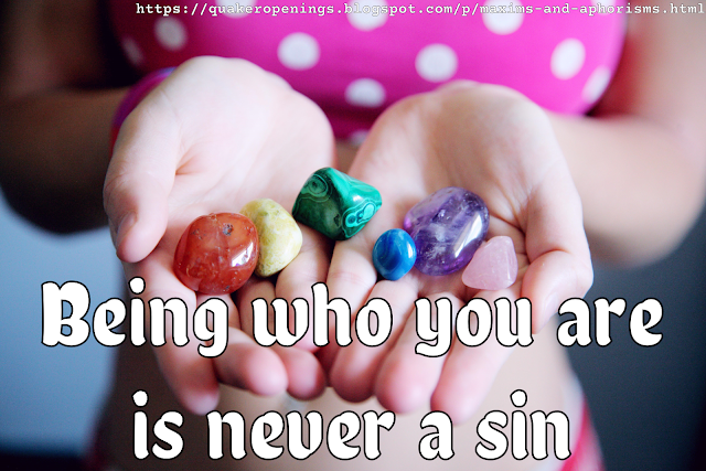 A woman in a pink top with white spots holds a series of semi-precious stones in her outstretched, cupped hands. The stones are in a rainbow of colours. Text overlay reads "Being who you are is never a sin".