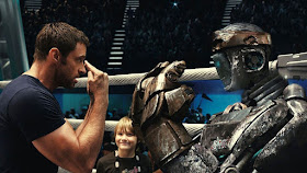Hugh Jackman enseñando al robot Atom ante la mirada de admiración de su "hijo" Max (Dakota Goyo).
