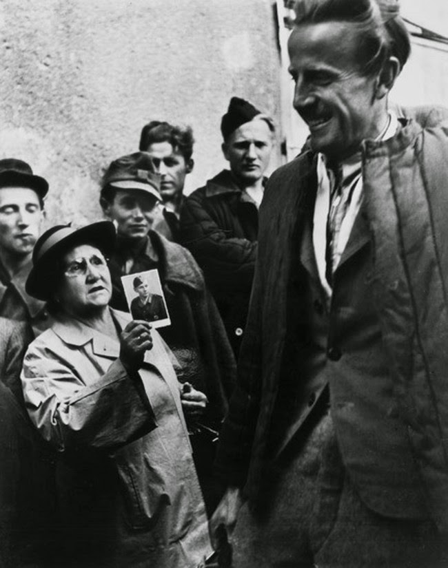 52 photos of women who changed history forever - A mother shows a picture of her son to returning prisoners of war in an attempt to find him. [Vienna, 1947]