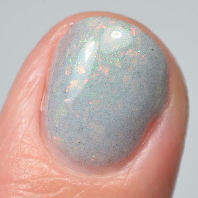 grey nail polish with flakies close up swatch