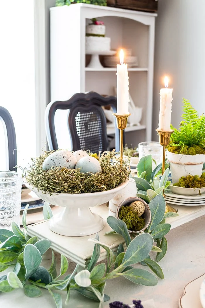 Spring centerpiece with nest of eggs, greenery, rabbits