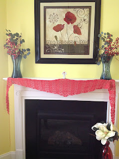 completed coral lace shawl displayed stretched across the fireplace mantel