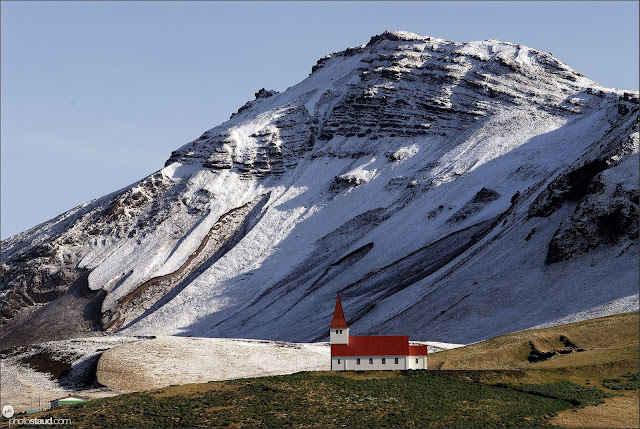 Isolated church of Vik on the south coast with snowy mountains behind, Iceland