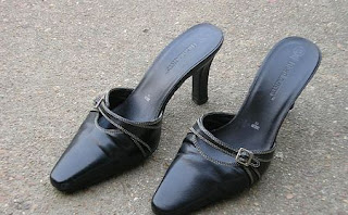 Black high heeled shoes with the back strap removed.