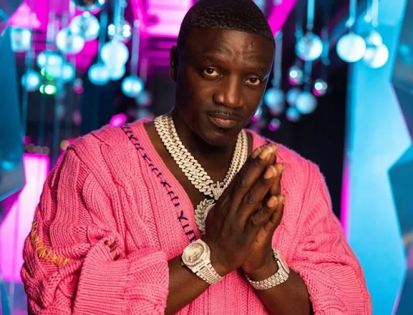Akon wearing jewels and pink outfit