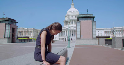 Movie still for Netflix's film Knock Down the House where Alexandria Ocasio-Cortez sits outside the United States Capitol building and reflecting after winning an election to become the U.S. Representative for New York's 14th congressional district