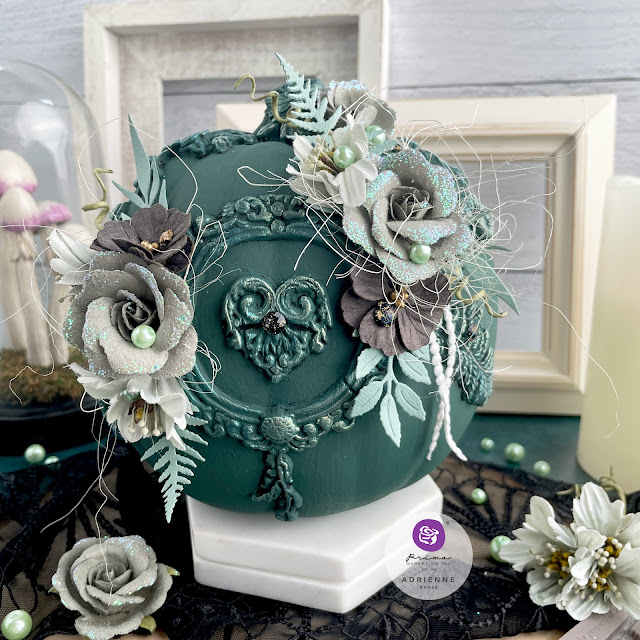 Dark green altered pumpkin with a dark academia aesthetic using moulds, flowers, pearls and gems from Prima Marketing Inc. (Lost in Wonderland, Twilight and The Plant Department Collections); Frank Garcia Memory Hardware; and Finnabair moulds, paint and wax.