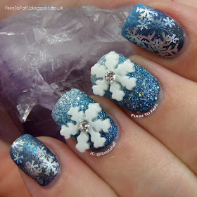 Snowflake nail art over blue gradient base with stamping and 3D nail charms.