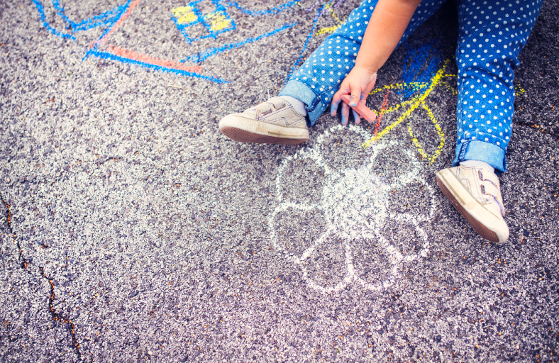 child drawing on pavement