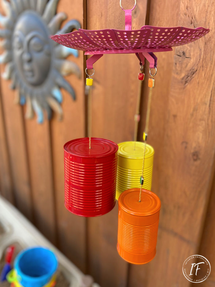 How to make bright and whimsical Upcycled Tin Can Wind Chimes with recycled food cans, a vintage strainer, and old necklace for unique garden decor.