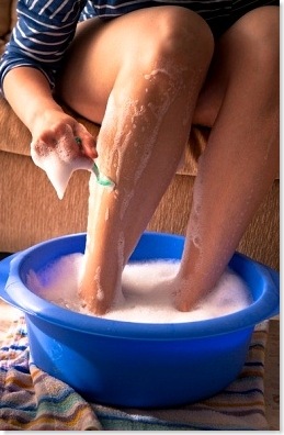 woman shaving her legs