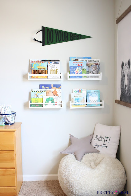 A cute reading nook with a bean bag for seating, fun art, wall mounted bookshelves