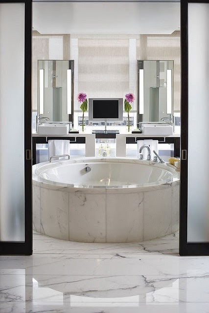 modern white master bathroom with round bath tub in marble