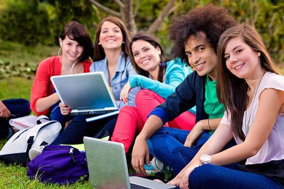 Grupo de jóvenes de universidad compartiendo informacion en sus laptos