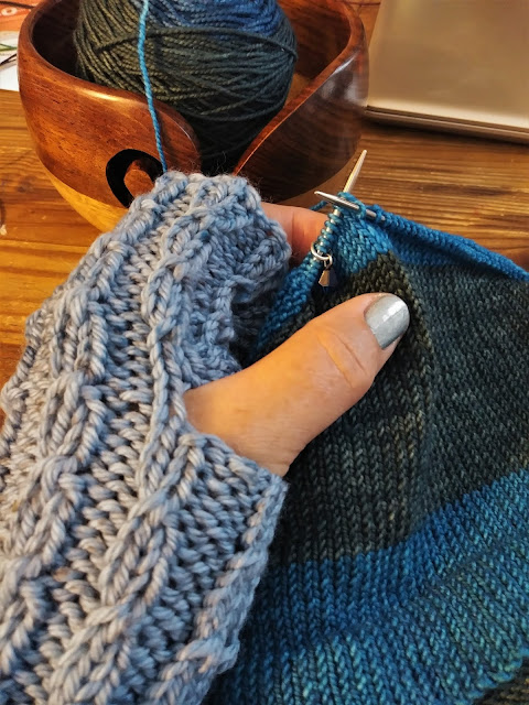 Warm fingerless gloves knit with an easy cable stitch and a blue hat knit with self striping washable wool yarn