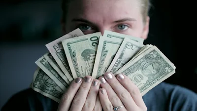 Currency notes held out and spread in fan shape.
