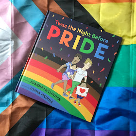 'Twas the Night Before Pride by Joanna McClintick and Juana Medina on a Progress Pride flag at a diagonal, top right to bottom left.