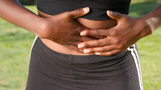 a woman holding her stomach | best rated chiropractor Ann Arbor