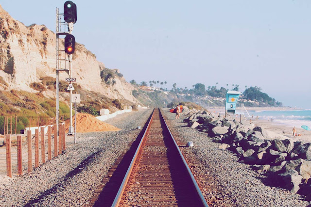 Vía de un tren al lado de una playa