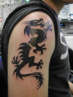 Simply black tribal dragon tattoo on a man's arm.