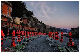 Umbrellas folded for the night, Monterosso al Mar, Cinque Terre,  Italy. Photo by Kent Johnson