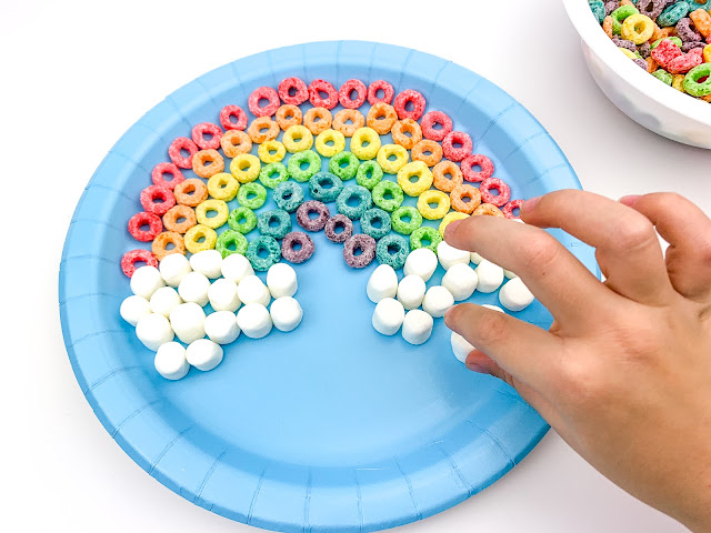 completed rainbow with hand placing marshmallow.