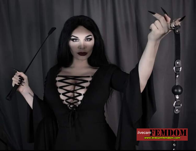 Domme on livecamfemdom with black ball gag and black riding crop