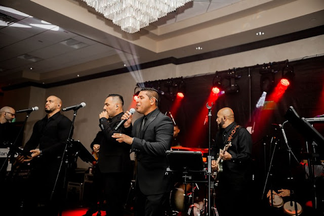 Band in all black singing and playing instruments at wedding