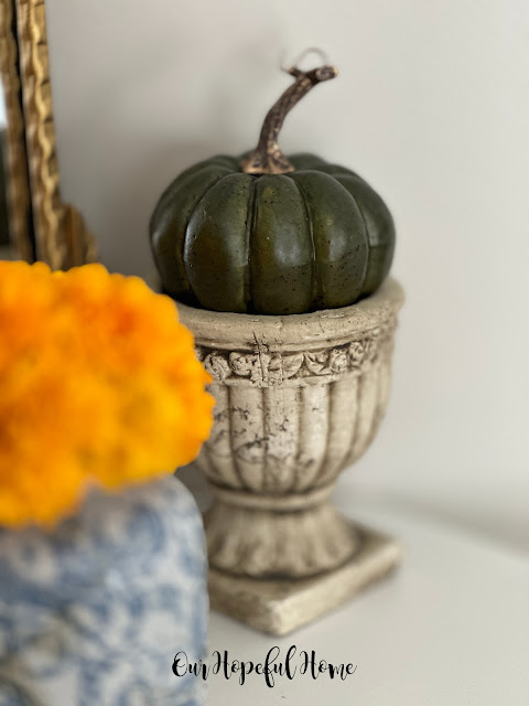 thrifted cement urn filled with pumpkin
