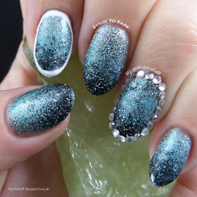 Loose glitter gradient nail art outlined with rhinestones and polish.