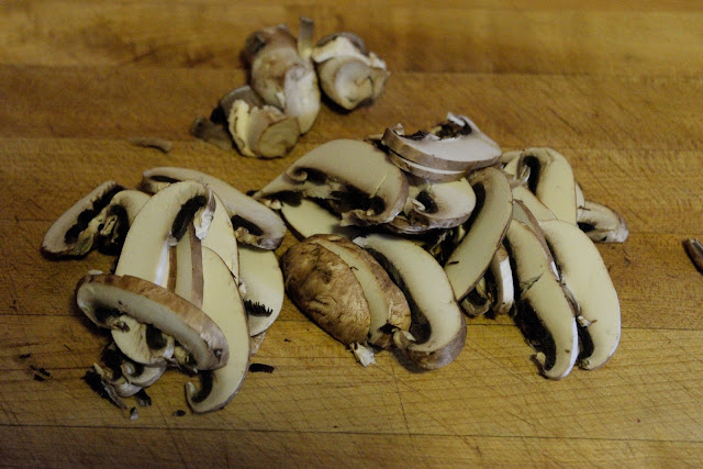 Sliced mushrooms on a cutting board.