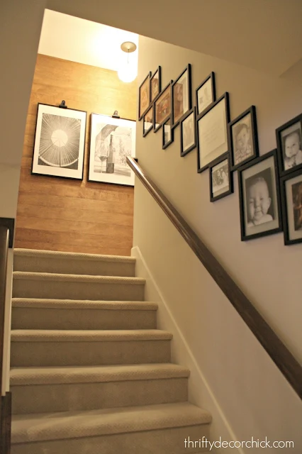 Gallery wall on stairs with wood accent wall