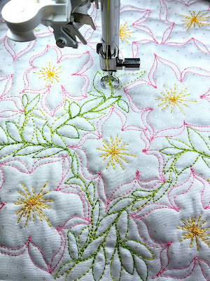 Stitched design of pink and yellow flowers and tiny green leaves